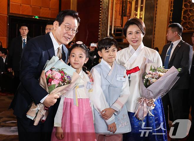 중국을 국빈 방문 중인 이재명 대통령과 김혜경 여사가 4일 베이징 한 호텔에서 열린 재중 한국인 간담회에서 화동에게 꽃다발을 전달 받은 후 기념촬영을 하고 있다. 2026.1.4/뉴스1 ⓒ News1 허경 기자