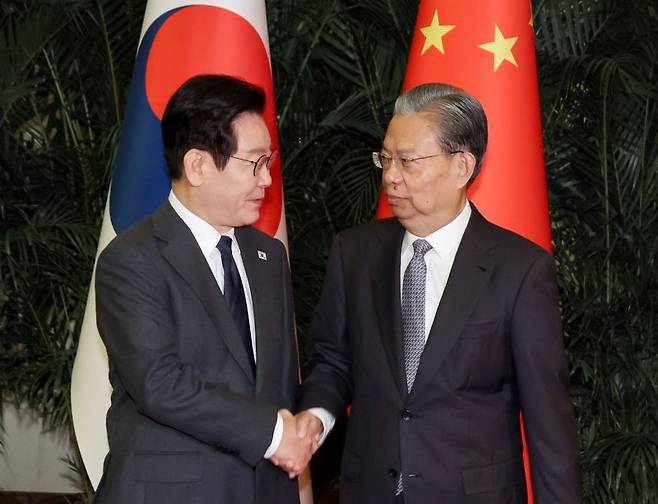 중국을 국빈 방문 중인 이재명 대통령이 6일(현지 시간) 베이징 인민대회당에서 자오러지 전국인민대표대회 상무위원장을 만나 악수하고 있다. 뉴시스