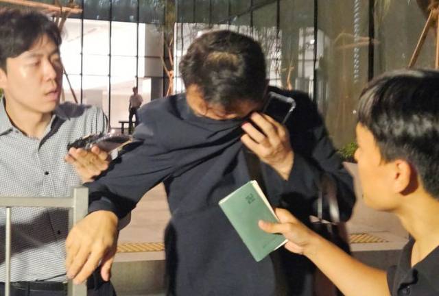 ▲김건희 전 코바나 대표 오빠인 김진우씨(사진 가운데)가 지난 28일 김 여사 관련 의혹들을 수사하는 민중기 특별검사팀 사무실이 위치한 서울 종로구 KT광화문빌딩에서 조사를 마친 뒤 얼굴을 가린 채 특검 사무실을 나서는 모습. ⓒ연합뉴스