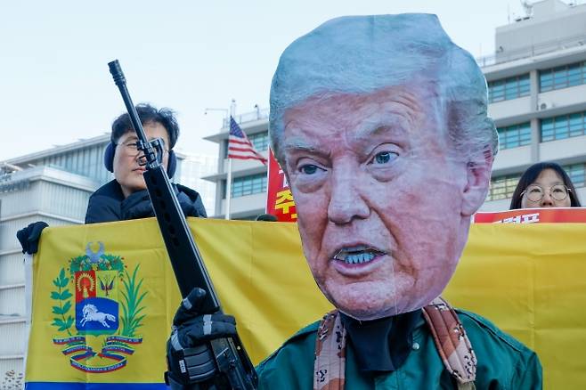 도널드 트럼프 미국 대통령 가면을 쓴 참가자가 5일 서울 종로구 주한미국대사관 앞에서 트럼프 1년 규탄 국제민중공동행동 조직위원회 주최로 열린 ‘트럼프 베네수엘라 침공 규탄 국제민중행동 긴급 기자회견’에서 포즈를 취하고 있다. 2026.1.5 뉴스1