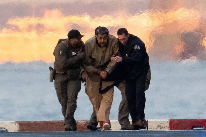 니콜라스 마두로 베네수엘라 대통령이 5일(현지시간) 미국 뉴욕 맨해튼 다운타운 헬리포트에서 미 연방 요원들의 호위를 받으며 맨해튼 연방법원으로 이동하고 있다. 마두로 대통령은 마약 테러 연루, 공모, 마약 밀매, 자금 세탁 등 혐의로 기소돼 첫 법정 출석을 앞두고 있다. 로이터 연합뉴스