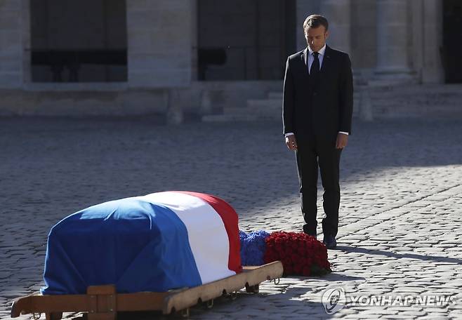 샹송 스타 앞 묵념하는 마크롱 대통령 (EPA 파리=연합뉴스) 2018년 10월5일 앵발리드에서 열린 샹송스타 아즈나부르 국가추도식에 참석한 마크롱 대통령이 고인의 관 앞에서 고개 숙여 묵념하고 있다.