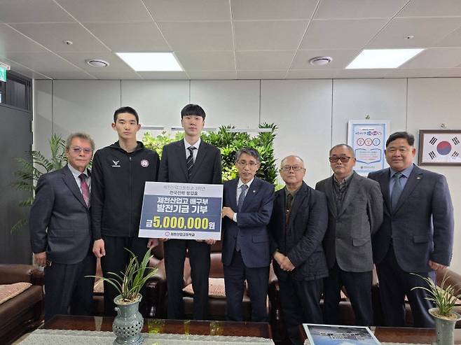 제천산업고등학교를 졸업한 방강호 한국전력 배구단 선수가 모교를 찾아 배구부 발전 기금을 기부한 뒤 학교 관계자들과 함께 기념 촬영을 하고 있다. (제천지원교육청 제공)