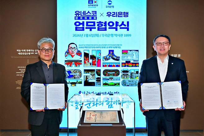 지난 6일 우리은행 역사관 ‘우리1899’에서 열린 협약식에서 우리은행 정진완(오른쪽) 은행장과 유네스코한국위원회 윤병순 사무총장 직무대행이 대한천일은행 창립청원서 앞에서 기념촬영을 하고 있다. 사진=우리은행 제공