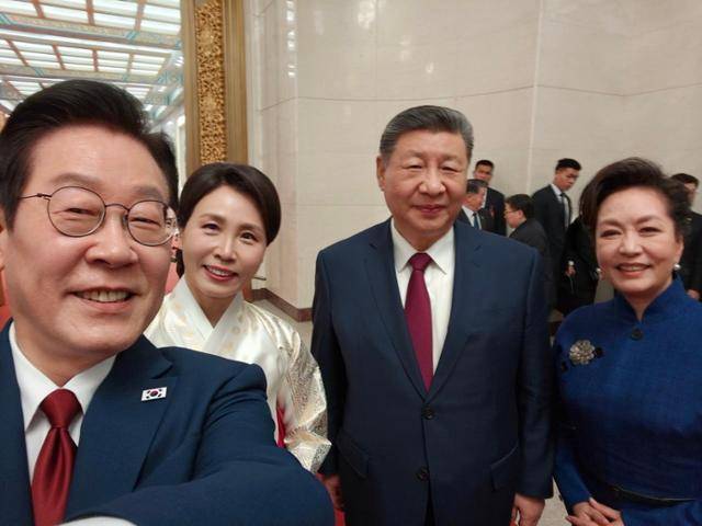이재명 대통령과 시진핑 중국 국가주석, 김혜경 여사와 펑리위안 여사가 5일 베이징 인민대회당에서 만찬 후 경주 APEC 때 선물 받은 샤오미폰으로 셀피를 촬영하고 있다. 이재명 대통령 SNS