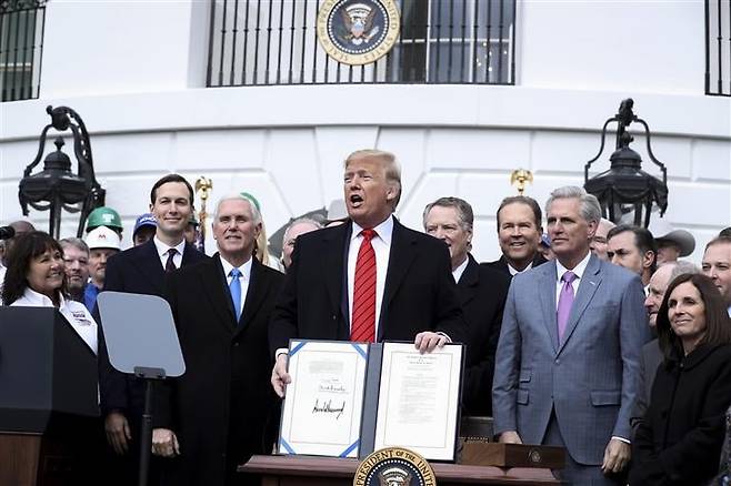 도널드 트럼프 미국 대통령이 2020년 1월 백악관 남쪽 잔디밭에서 미국-멕시코-캐나다 무역협정(USMCA)을 들고 있다. EPA연합뉴스