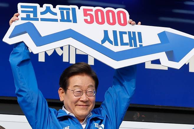 이재명 대통령이 대선 후보 시절 유세에서 ‘코스피 5000시대’라고 적힌 피켓을 높이 들고 있다. 사진=뉴스1