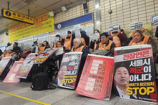 Members of Solidarity Against Disability Discrimination, including its leader Park Kyung-seok (front row, third from right) hold a press conference at Hyehwa Station on Subway Line No. 4 on Wednesday. (Yonhap)