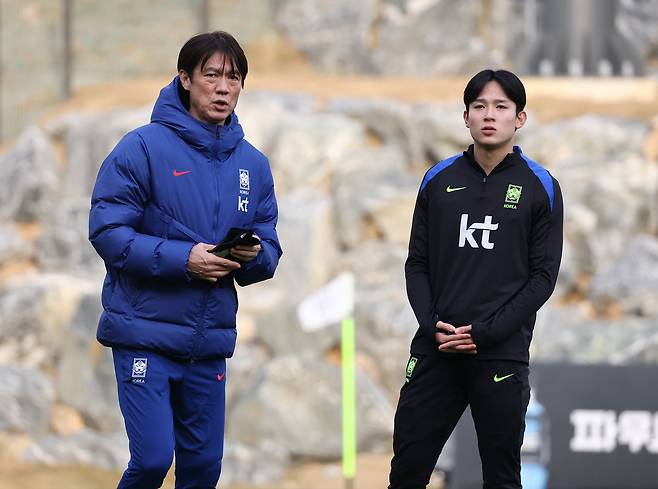 Yang Min-hyeok, right, chats with his head coach Hong Myung-bo before a training session at the National Football Center in Cheonan, South Chungcheong, on Nov. 11, 2025. [YONHAP]