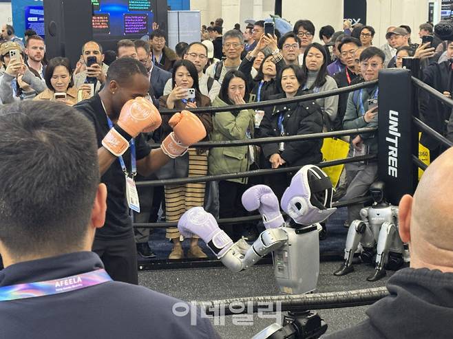 중국 로봇 기업 유니트리의 인간형 로봇(휴머노이드) G1이 링 위에서 사람과 권투를 하고 있다.(사진=공지유 기자)