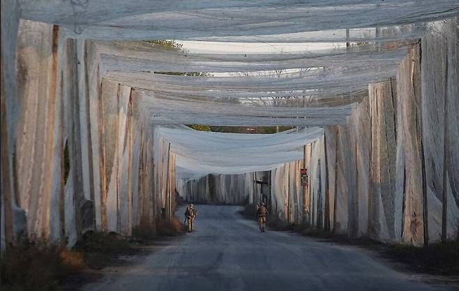 지난해 11월3일 우크라이나 도네츠크의 최전선 도시인 코스티안티니우카. 우크라이나 병사들이 드론 방어 그물로 뒤덮힌 도로를 순찰하고 있다. 로이터 연합뉴스