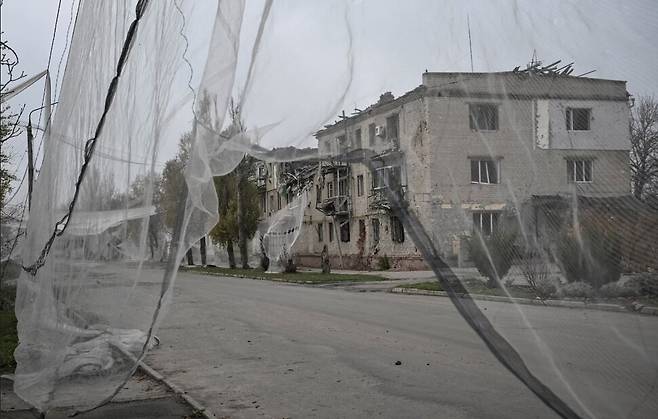 지난해 11월13일 우크라이나 자포리자의 전선 도시 오리키우. 러시아군의 폭격을 받아 파괴된 주택들이 늘어선 도로에 드론 방어 그물이 드리워 있다. 로이터 연합뉴스