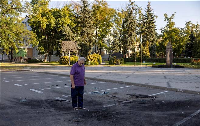 지난해 9월10일 우크라이나 도네츠크의 크라마토르스크. 한 주민이 드론 폭발로 인해 손상된 도로를 살피고 있다. 로이터 연합뉴스