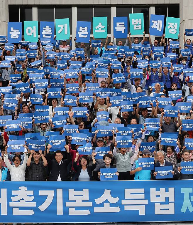 서울 여의도 국회 본청 앞 계단에서 지난해 8월 열린 농어촌기본소득법 제정 촉구 기자회견에서 참가자들이 구호를 외치고 있다. 연합뉴스