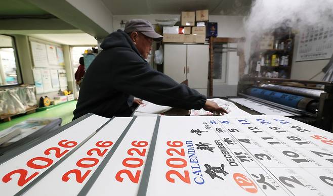 An employee makes calendars for 2026, the Year of the Fire Horse, at a calendar printing shop in Jangan District, Suwon, Gyeonggi Province, on Nov. 3, 2025. [NEWS1]