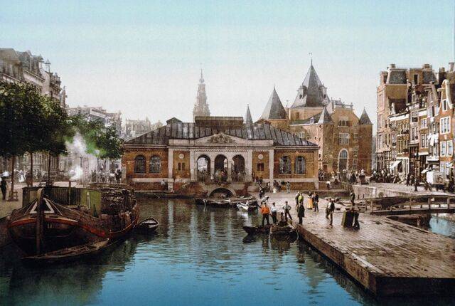 1900년경 네덜란드 암스테르담의 어시장과 공공 계량소 건물 주변 풍경. 신학자 헤르만 바빙크가 1902년부터 생애를 마감할 때까지 활동했던 도시의 당시 모습으로, 카메라로 포착한 흑백의 현실에 색을 더하는 포토크롬 기법이 그림 같은 독특한 분위기를 자아낸다. 포토글로브 취리히