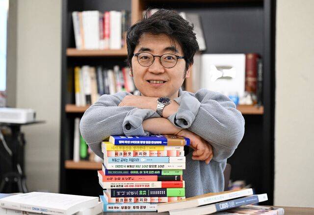 부동산 유튜브 채널 ‘채부심’ 운영자인 채상욱씨가 지난 15일 서울 중구 사무실에서 자신의 저서들을 쌓아놓고 포즈를 취하고 있다. 이한형 기자