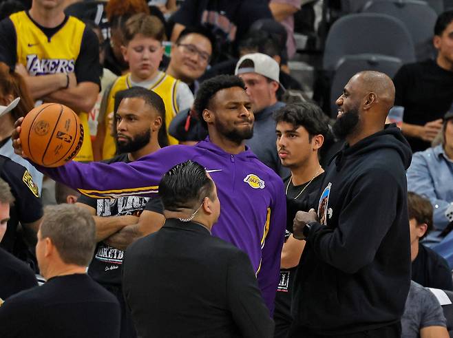 르브론 제임스(오른쪽)가 8일 미국 텍사스주 샌안토니오의 프로스트 뱅크 센터에서 열린 샌안토니오 스퍼스와 2025~2026 미국프로농구 정규리그 원정 경기에서 브로니 제임스를 보며 미소짓고 있다.   샌안토니오 | AFP연합뉴스