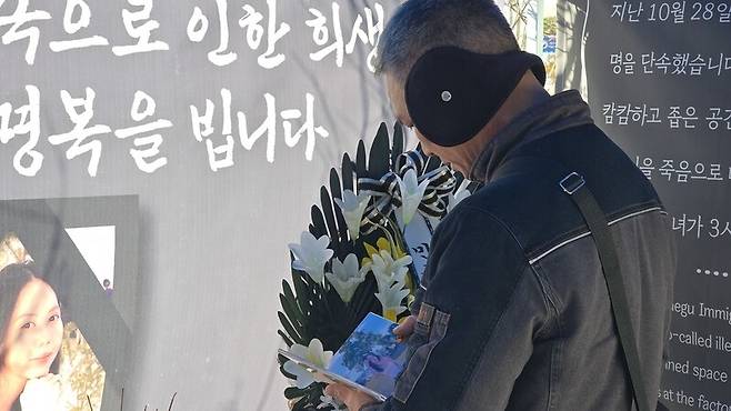 9일 대구시 동구 대구출입국외국인사무소 앞에 차려진 뚜안(가명·25) 추모 분향소에서 아버지 부반숭(59)이 뚜안의 사진을 들어 보고 있다. 김규현 기자