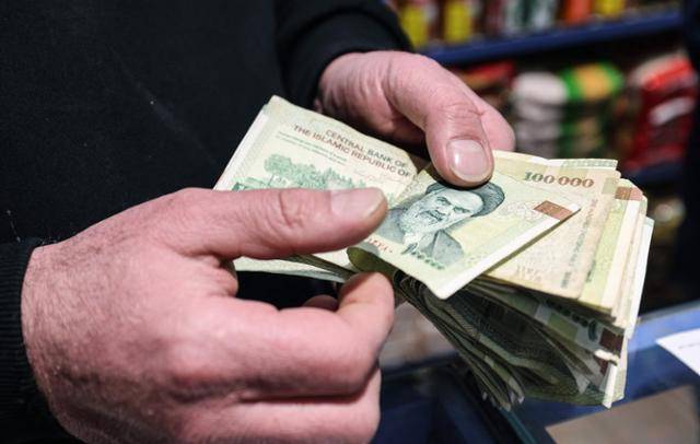イランのテヘランで７日、リアル紙幣の枚数を数える店主。イランは深刻な経済的困難に苦しんでおり、国際制裁と戦争により通貨価値が過去１年で４０％以上下落した。テヘラン＝AFP聯合ニュース