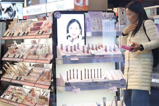지난달 21일 서울 명동 거리에서 외국인들이 화장품을 둘러보고 있다. 한국보건산업진흥원에 따르면 국내 화장품 전자상거래 수출액은 2019년 5천만 달러에서 2023년 3억5천만 달러로, 연평균 62.7% 급증했다. 연합뉴스