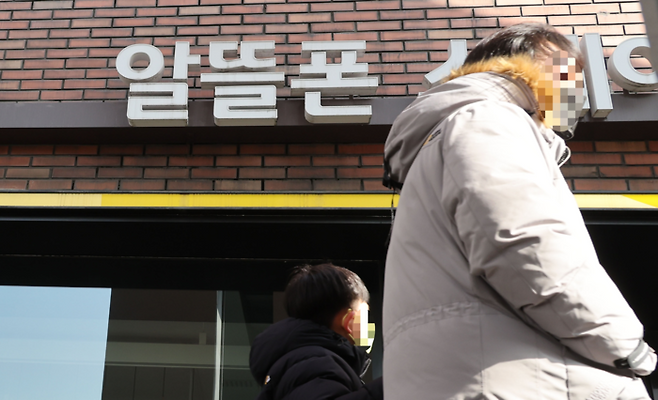 시민들이 서울의 한 알뜰폰 매장 앞을 지나가는 모습. [이승환 기자]