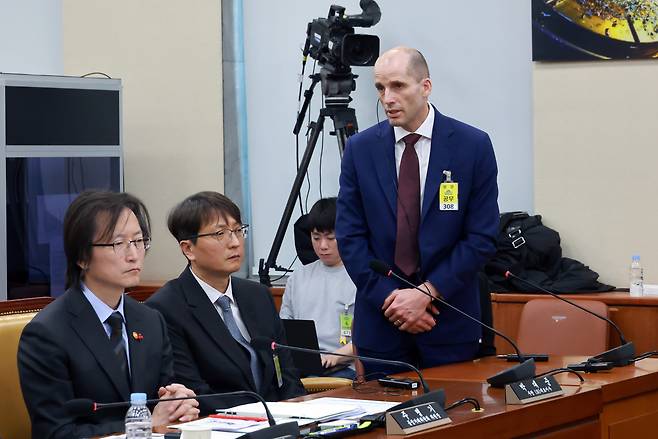 지난해 12월 30일 국회에서 열린 ‘쿠팡 청문회’에서 해롤드 로저스 쿠팡 대표이사가 쿠팡에서 일하다 숨진 노동자의 유족을 향해 사과하고 있다. 주병기 공정거래위원장(왼쪽)과 박대준 전 쿠팡 대표(가운데)도 청문회에 참석했다. 연합뉴스