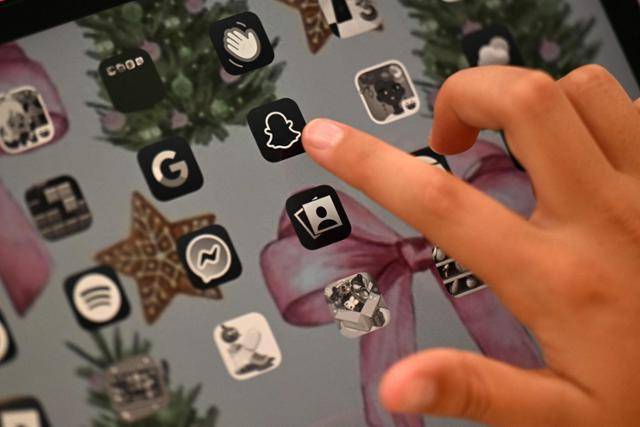 호주 시드니에 거주하는 한 10세 아동이 16세 미만 청소년 SNS 접속 금지 조치가 시행된 지난달 10일 자신의 모바일 기기에 설치돼 이는 스냅챗 앱을 가리키고 있다. 시드니=AFP 연합뉴스