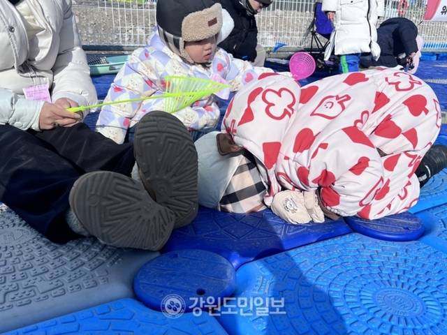 ▲ 송어가 잡히는지 확인하기 위해 6살 어린이가 구멍을 들여다보고 있다. 박지윤 기자