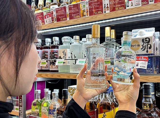 편의점을 방문한 고객이 중국 술을 살펴보고 있는 모습. <자료 = 세븐일레븐>