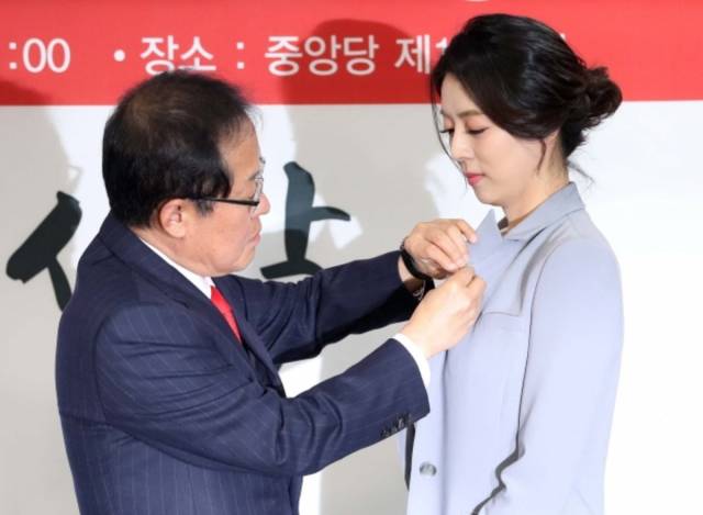 ▲2018년 3월 9일 서울 여의도 자유한국당(국민의힘 전신) 당사에서 열린 영입인사 환영식에서 홍준표 당시 대표가 입당한 배현진 의원(당시 전 MBC 앵커)에게 태극기 배지를 달아주고 있다. ⓒ연합뉴스