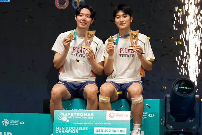 김원호(오른쪽)와 서승재가 11일(현지 시간) 말레이시아 쿠알라룸푸르 악시아타 아레나에서 열린 2026 세계배드민턴연맹(BWF) 월드 투어 슈퍼 1000 말레이시아오픈 남자 복식 정상에 올라 금메달을 들고 포즈를 취하고 있다. 김원호-서승재 조는 결승에서 애런 치아-소위익 조(말레이시아)를 2-1(21-15 12-21 21-18)로 꺾고 대회 2연패를 달성했다.뉴시스