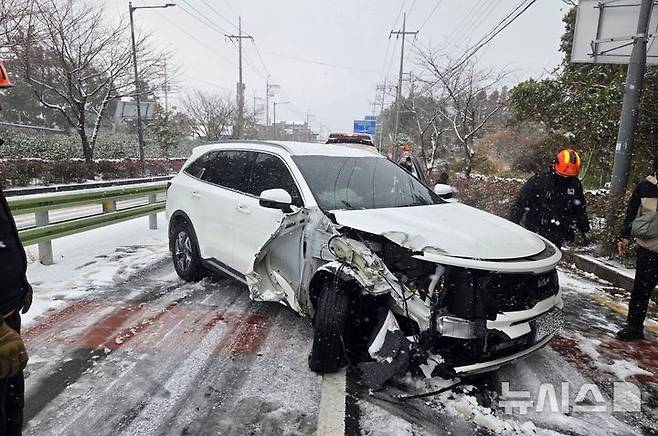 [서귀포=뉴시스] 11일 오전 제주 서귀포시 동홍동 인근 도로에서 차량이 눈길에 미끄러져 출동한 119가 안전조치를 하고 있다. (사진=제주도소방안전본부 제공) 2026.01.11. photo@newsis.com *재판매 및 DB 금지