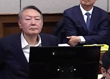 윤석열 전 대통령이 9일 서울 서초구 서울중앙지방법원에서 열린 내란 우두머리 혐의 1심 결심 공판에 출석해 자리에 앉아 있다. 서울중앙지방법원 제공 영상 캡쳐. 뉴스1