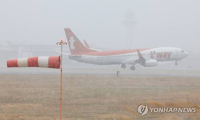 눈보라 속 힘겨운 착륙 (제주=연합뉴스) 박지호 기자 = 제주국제공항에 강풍특보와 급변풍특보가 내려진 11일 오전 한 항공기가 눈보라를 뚫고 활주로에 착륙하고 있다. 2026.1.11 jihopark@yna.co.kr
