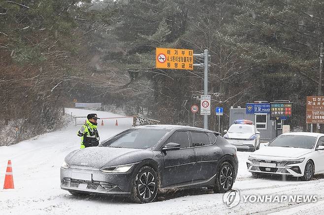 폭설에 제주 주요 산간도로 통제 (제주=연합뉴스) 박지호 기자 = 폭설이 쏟아진 11일 오전 제주시 어승생 삼거리 1100도로 입구에서 경찰이 차량 진입을 통제하고 있다. 2026.1.11 jihopark@yna.co.kr