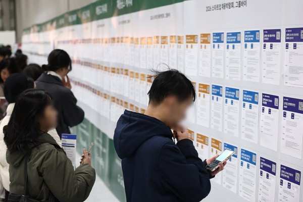 지난 11일 서울 강남구 코엑스에서 열린 '2026 스타트업 채용박람회'를 찾은&nbsp;구직자들이 채용공고 게시대를 살펴보고 있다. 연합뉴스