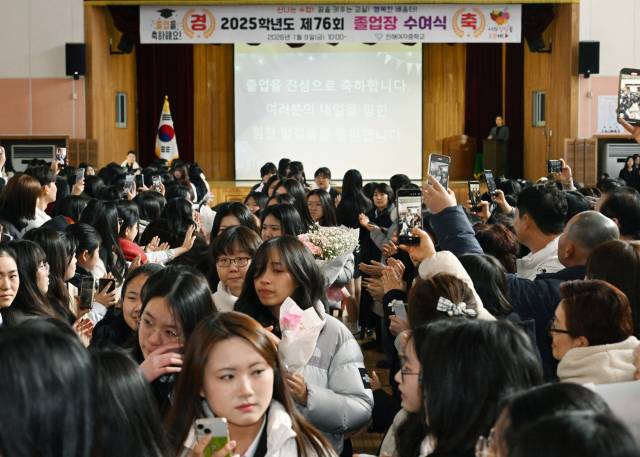 9일 창원시 진해구 진해여자중학교 체육관에서 열린 마지막 졸업식에서 졸업생들이 1·2학년 재학생들의 환송을 받으며 학교를 나서고 있다. /김승권 기자/