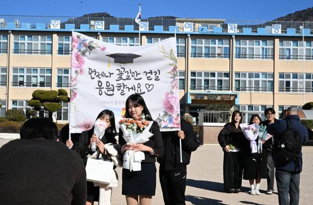 9일 창원시 진해구 진해여자중학교 마지막 졸업식에서 졸업생들이 교정을 배경으로 기념사진을 남기고 있다. /김승권 기자/