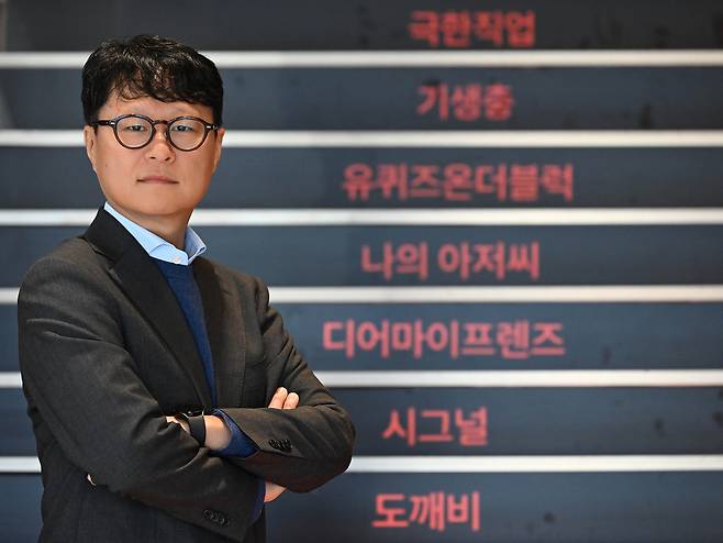Yea Ju-yeol, head of CJ ENM's Performing Arts Division, poses in front of a staircase displaying the names of the company’s top titles at the CJ ENM Center in Sangam-dong, Mapo-gu, Seoul, on Dec. 3. (Lee Sang-sub/The Korea Herald)