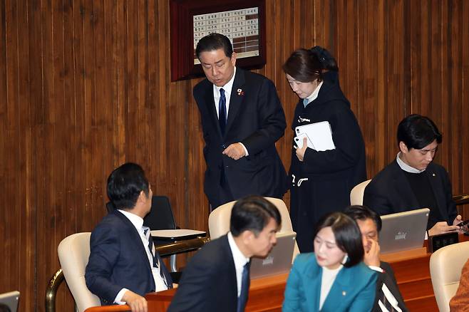 Kim Byung-kee, then floor leader of the Democratic Party, and Rep. Kang Sun-woo walk and talk during the second plenary session of the 430th National Assembly at the National Assembly in Yeouido, western Seoul, on Dec. 24, 2025. [NEWS1]