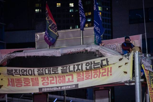 ▲서울 명동 세종호텔 앞 도로구조물 위에서 복직을 촉구하며 고공농성 중인 고진수 세종호텔지부장. ⓒ민주노총