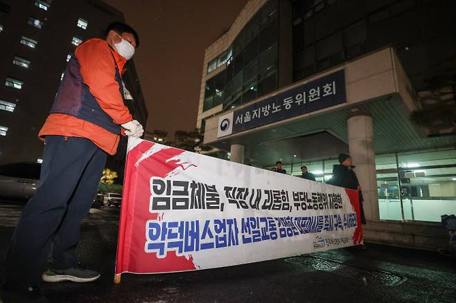 서울 시내버스 노조 파업 예고일을 하루 앞두고 특별조정위원회 사후 조정회의가 열린 12일 서울 영등포구 서울지방노동위원회에서 전국민주노동조합총연맹(민주노총) 민주버스본부 서울지부 조합원들이 사측을 규탄하는 현수막을 펼치고 있다.(사진=연합뉴스)