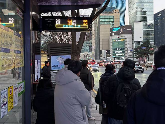 13일 오전 7시 서울 강남구의 한 버스 정류장에서 승객이 버스를 기다리는 모습. 파업으로 시내 버스 운행이 중단되면서 전광판엔 버스 위치가 '차고지'로 표시되고 있다. 류효림 기자