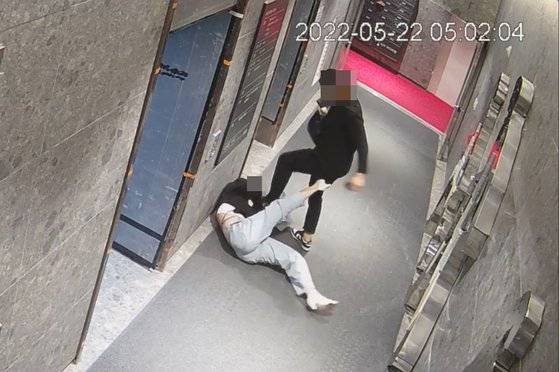 CCTV footage shows a man kicking a woman in the head at her apartment building in Busan on May 22, 2022. The man was sentenced to 20 years in prison for attempted murder and sexual assault. [JOONGANG ILBO]