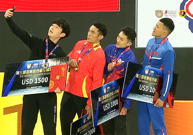 대한MMA총협회 김민건이 2026년 1월 제3회 아시아종합격투기협회 선수권대회 남자 현대 65㎏ 은메달리스트로서 시상자들의 셀카 촬영을 주도하고 있다. 종합격투기는 9월 20~22일 제20회 일본 아이치-나고야 하계아시안게임 정식 종목으로 치러진다. 사진=AMMA