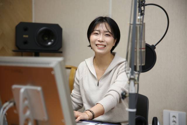 최원혜 성서공동체FM 사무국장이 방송 스튜디오에 앉아 활짝 웃고 있다. 김도훈 기자