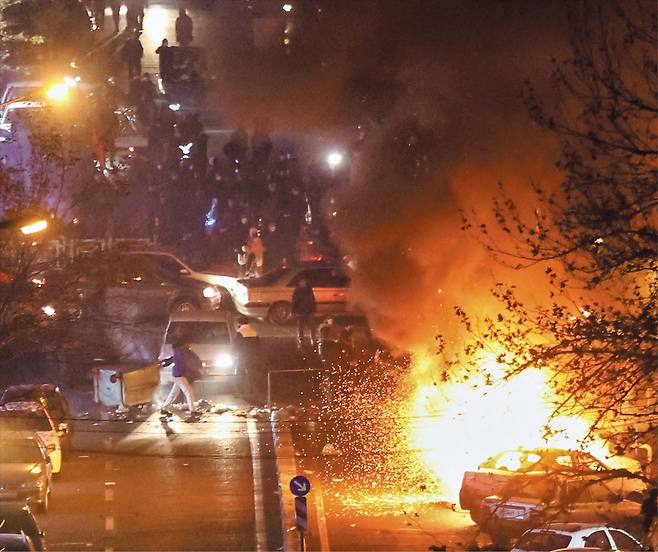 지난 8일 이란 수도 테헤란에서 반정부 시위대와 이를 진압하는 이슬람혁명수비대 등 보안군이 충돌해 차량들이 불타고 있다. /로이터 연합뉴스