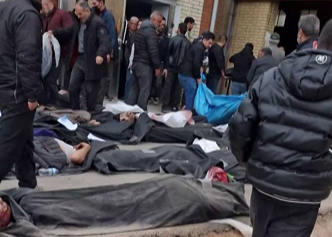 14일(현지시간) 소셜미디어에 게시된 영상을 캡처한 화면에는 이란 테헤란주 카흐리자크에 위치한 법의학 진단·검사센터 바닥에 수십 구의 시신이 놓여 있고, 유가족들이 가족을 찾고 있는 모습이 담겨 있다. AFP=연합뉴스