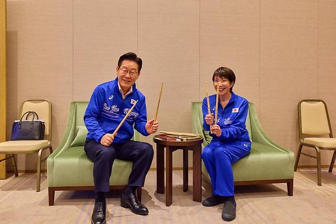 President Lee Jae Myung, left, holds up drum sticks that Japanese Prime Minister Sanae Takaichi gifted to him during Lee's visit to Nara, Japan, on Jan. 13. [JOINT PRESS CORPS]